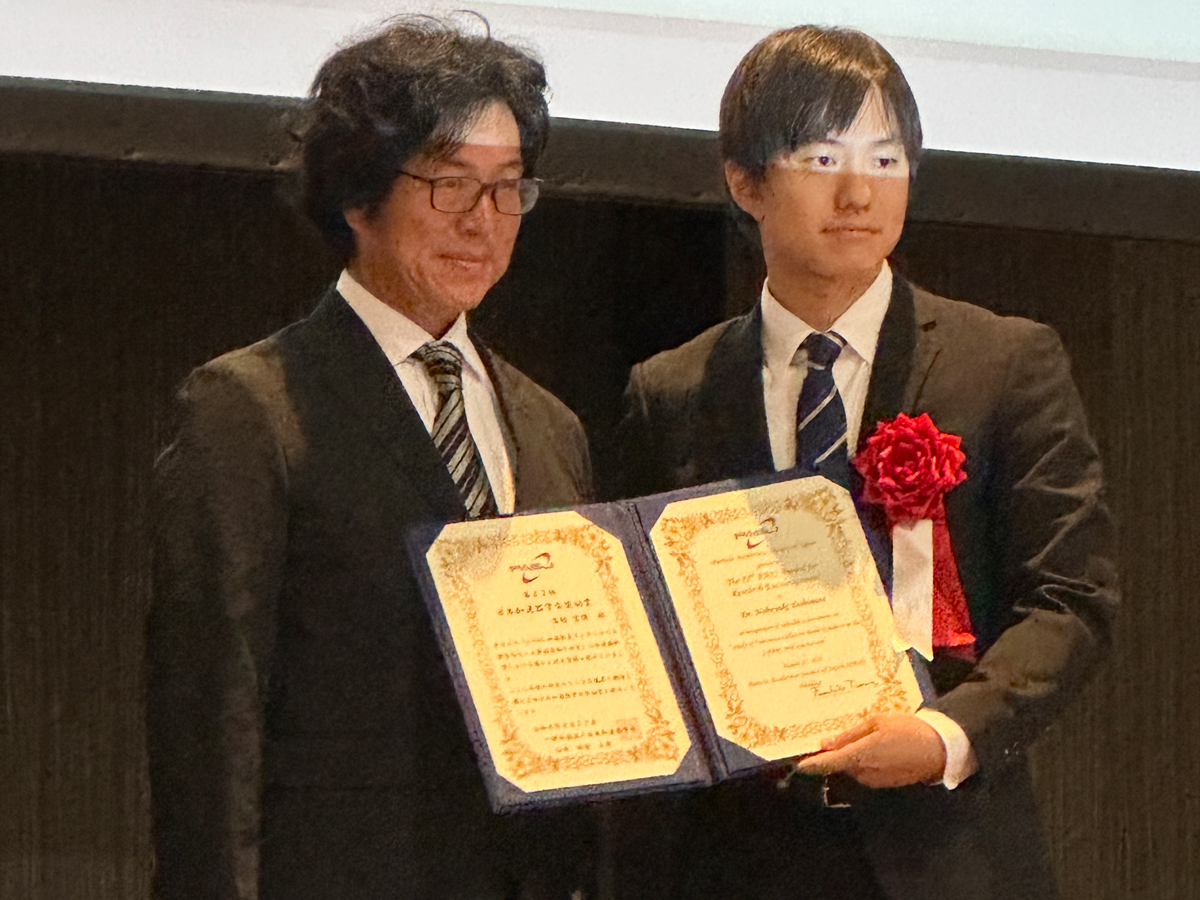 授賞式にて。田村 文彦(たむら・ふみひこ)加速器学会会長(JAEA/J-PARC、左)と吉村 宣倖さん